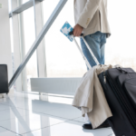 hombre en el aeropuerto con una maleta y el pasaporte. consejo para viajar de forma segura.