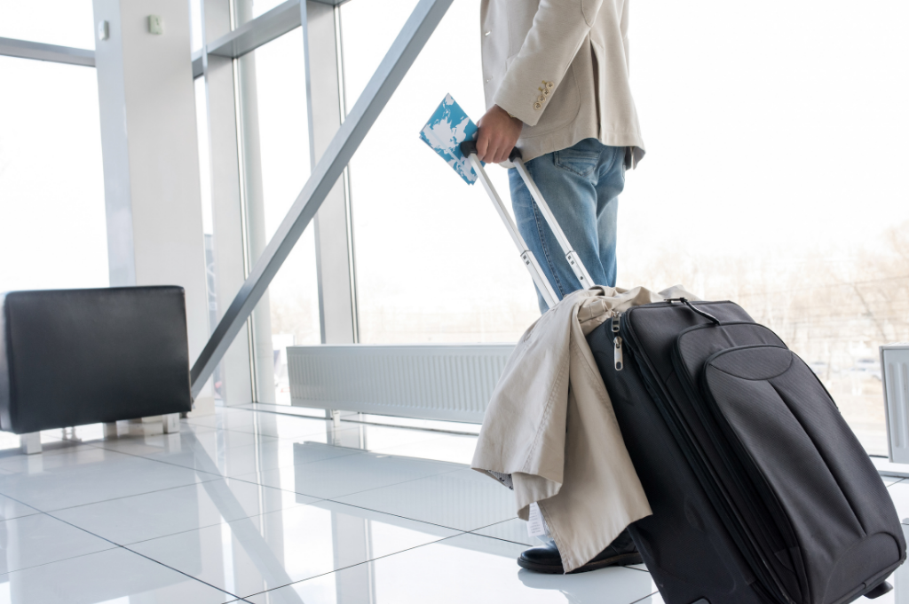 hombre en el aeropuerto con una maleta y el pasaporte. consejo para viajar de forma segura.